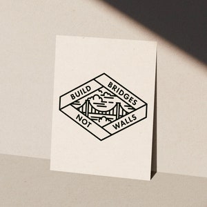 May include: Black and white line art print with a graphic of a bridge and the text "BUILD BRIDGES NOT WALLS".