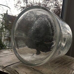 May include: A clear glass jar with a textured surface. The jar is empty and has a wide mouth.