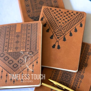 Pode incluir: Quatro diários de couro castanho com desenhos geométricos pretos. Os diários têm uma borda branca e o texto "TIMELESS TOUCH DESIGNS" está impresso na capa de um diário.