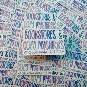 May include: A stack of colorful stickers with the text "Bookstores & Cozy Mysteries" and the website address "angelamariahart.com".