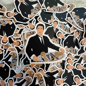 Op de afbeelding: Een stapel zwart-wit stickers met een man in pak die een dienblad met verschillende items vasthoudt. De man glimlacht en heeft een donkere huidskleur. De stickers zijn gedrukt op wit papier en hebben een glanzende afwerking.