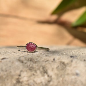 Peut inclure: Une bague en argent avec une pierre précieuse rose sertie au centre.