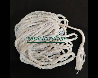 May include: A strand of white opal beads, approximately 16 inches long, with a white tassel. The beads are small and round, and the strand is coiled up. The text "garnetcreation" is visible in the image.