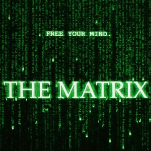 Op de afbeelding: Een donkere afbeelding met de woorden "THE MATRIX" in heldergroen en de zin "FREE YOUR MIND" erboven. De achtergrond is een waterval van groene code, die een digitaal regen-effect creëert, wat doet denken aan de iconische esthetiek van de film.