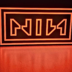 May include: An illuminated orange sign displaying the letters "NII" within a rectangular frame. The sign glows against a dark backdrop, creating a striking contrast. The letters are stylized and modern in appearance.