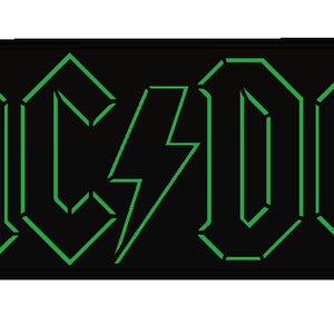 Könnte beinhalten: Schwarzer rechteckiger Aufnäher mit dem Bandnamen "AC/DC" in grüner, stilisierter Schrift und einem Blitz-Grafik. Der Aufnäher hat einen schwarzen Rand und ist wahrscheinlich für Kleidung oder Accessoires.