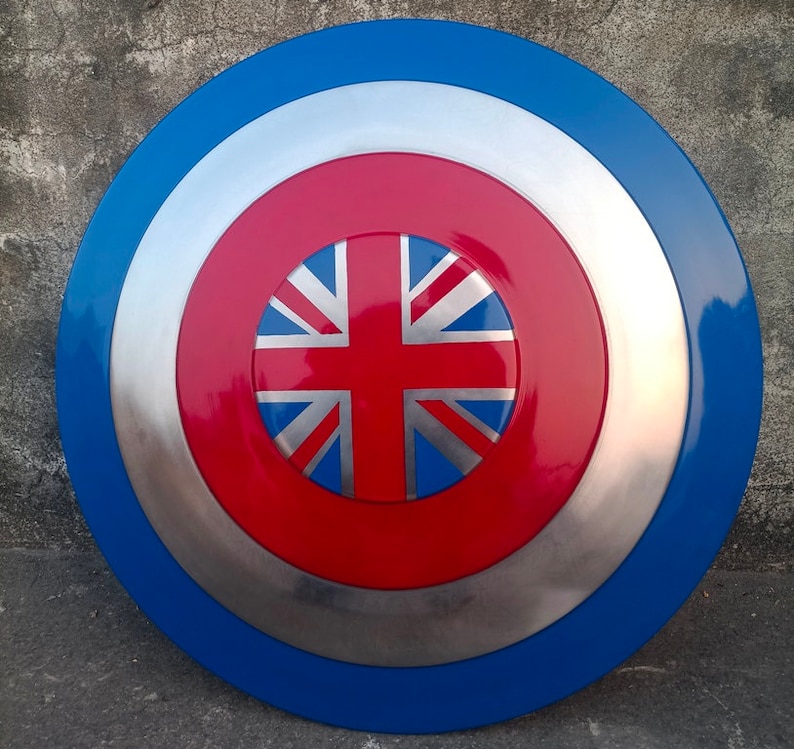Op de afbeelding: Een rood, wit en blauw schild met een Union Jack-ontwerp in het midden. Het schild is gemaakt van metaal en heeft een zilveren rand.