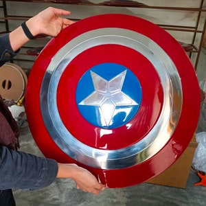 May include: A red, white and blue Captain America shield with a silver metal rim. The shield has a five-pointed star in the centre.