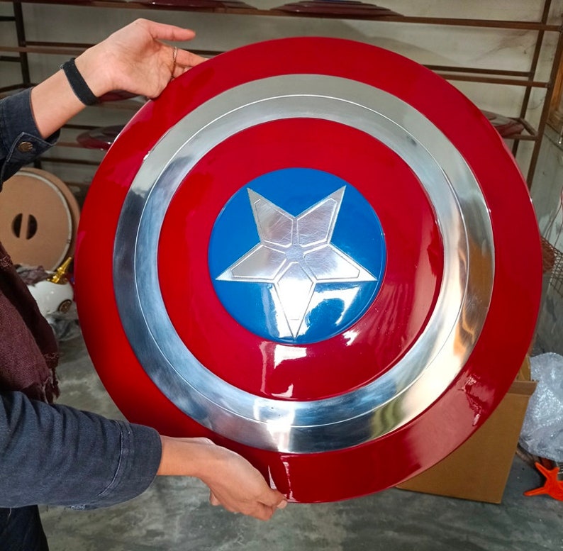 May include: A red, white and blue Captain America shield with a silver metal rim. The shield has a five-pointed star in the centre.
