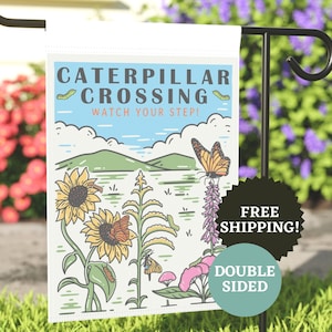 May include: A white garden flag with a colorful illustration of a butterfly, sunflowers, and caterpillars. The text on the flag reads "Caterpillar Crossing Watch Your Step!"
