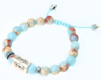 May include: A blue and brown beaded bracelet with a silver charm and a blue cord with silver toggles.