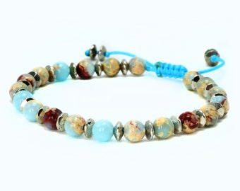 May include: A blue and brown beaded bracelet with silver accents and a blue cord closure.