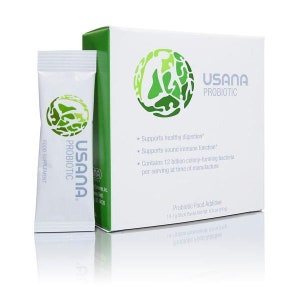 May include: A white box with green accents and the text "USANA PROBIOTIC" on the front. The box contains 14-19 stick packs of a probiotic food additive. The box also includes a list of benefits, including supporting healthy digestion and immune function. The box is sitting on a white surface.