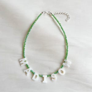Collar con nombre o palabra personalizado con cuentas de vidrio verde oscuro con letras de nácar; cierre bañado en plata, plata de ley o chapado en oro
