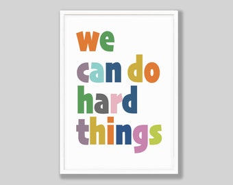 May include: A white framed print with the text "we can do hard things" in colorful, overlapping letters.