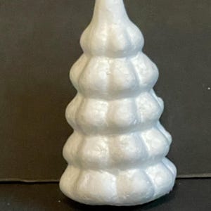 May include: White styrofoam Christmas tree with a textured surface. The tree is shaped like a cone and has a pointed top.