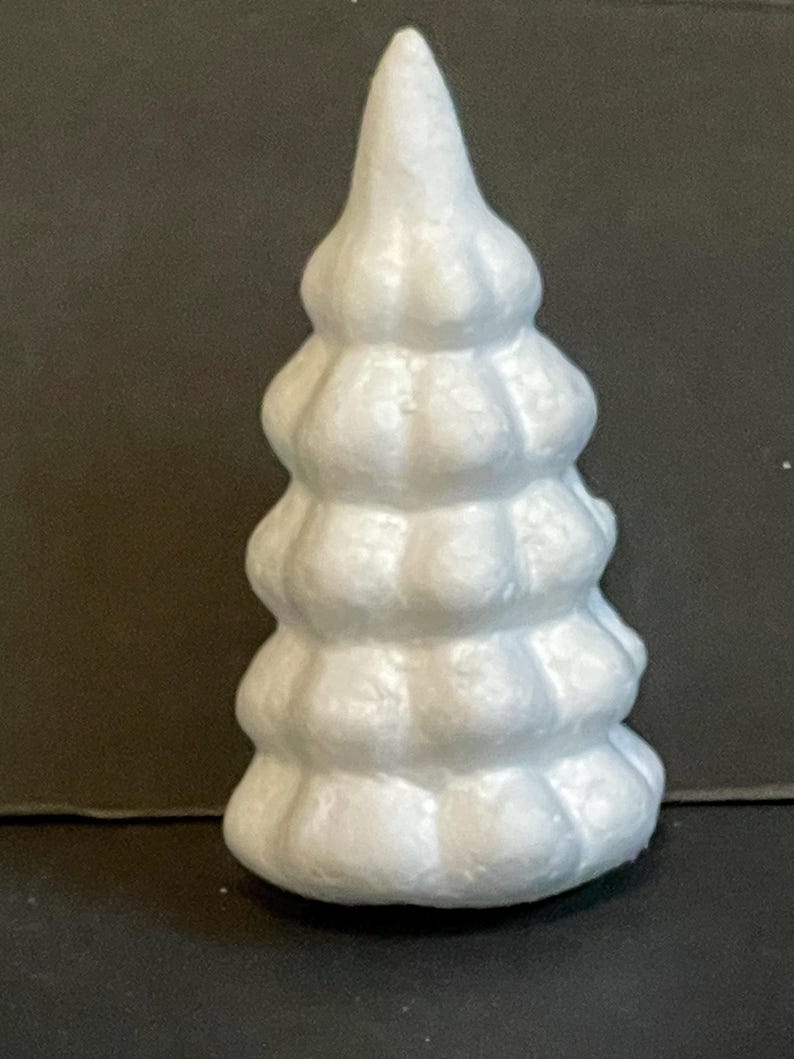 May include: White styrofoam Christmas tree with a textured surface. The tree is shaped like a cone and has a pointed top.