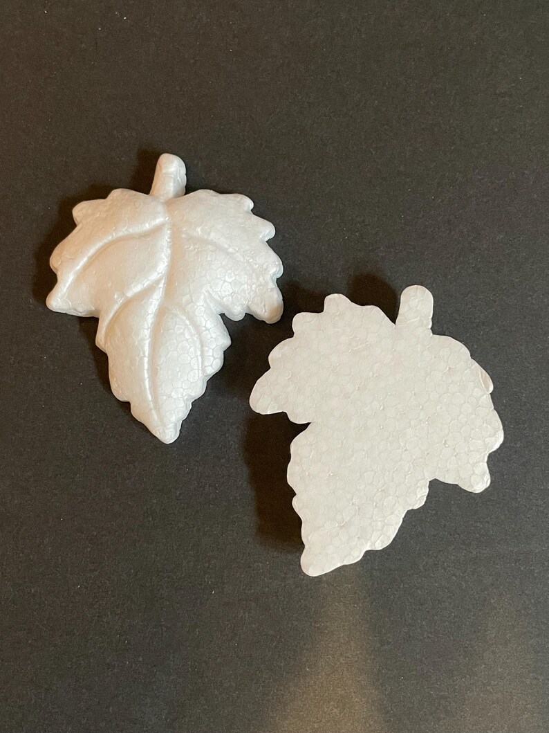 May include: Two white foam leaves, one with a more detailed vein pattern, are shown against a black background.