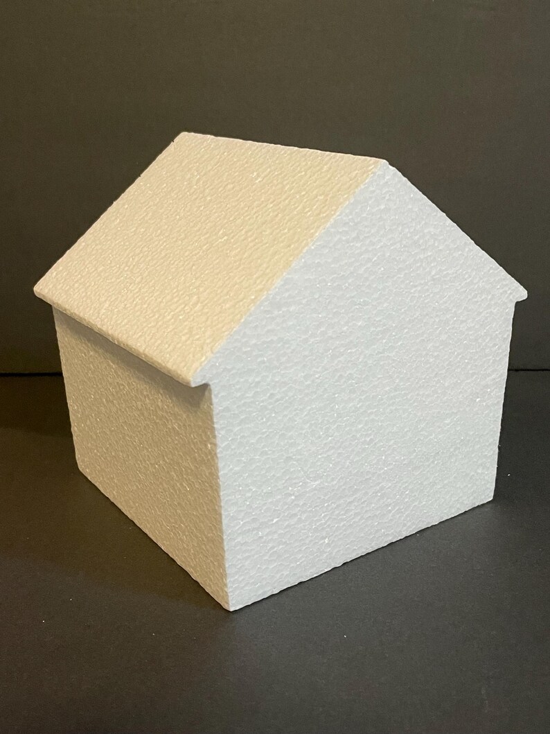 May include: A white polystyrene house shaped cake dummy. The cake dummy is a blank canvas for decorating.