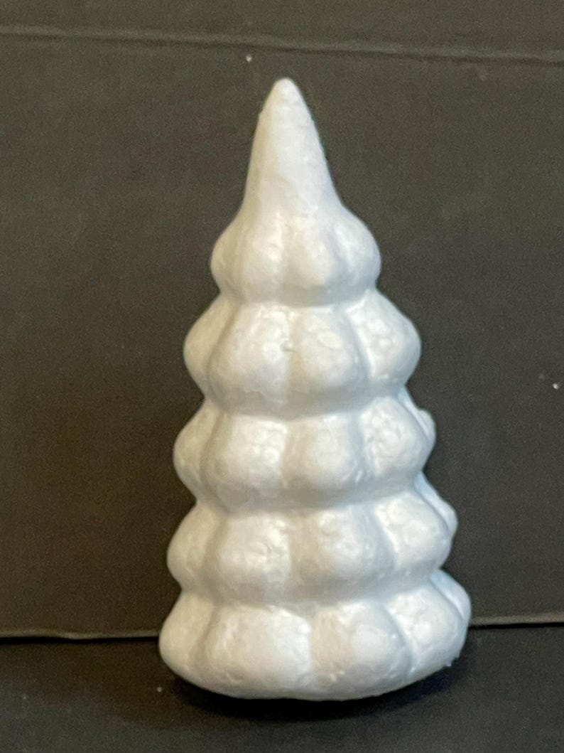 May include: White styrofoam Christmas tree with a textured surface. The tree is shaped like a cone and has multiple tiers.