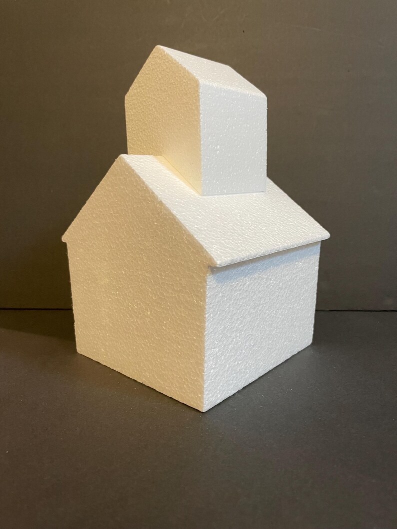 May include: A white polystyrene cake dummy shaped like a house with a smaller house on top. The cake dummy is ideal for practising cake decorating techniques.
