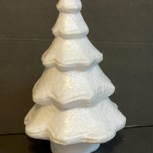 May include: White styrofoam Christmas tree with a textured surface. The tree is approximately 15 cm tall.