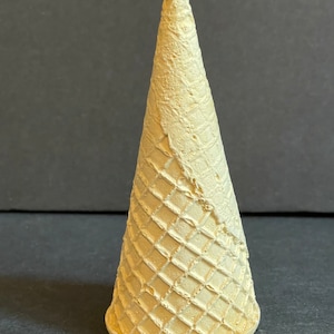 May include: A light brown waffle cone, a classic ice cream cone shape.