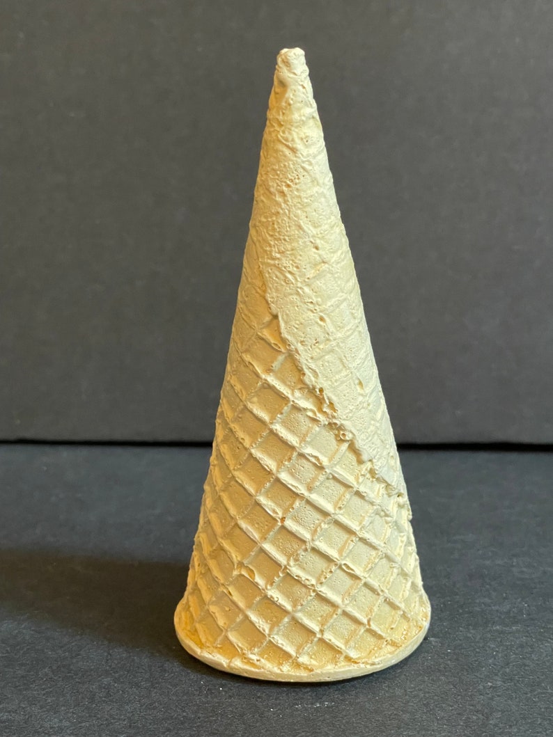 May include: A light brown waffle cone, a classic ice cream cone shape.