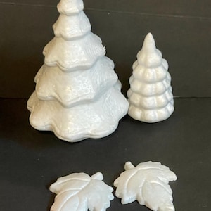 May include: A set of white foam craft supplies for creating a winter scene. The set includes two trees of different sizes and two leaves.