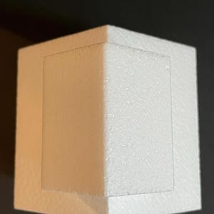 May include: White polystyrene cake dummy with a square base and a smaller square top. The top is offset from the base, creating a tiered effect.