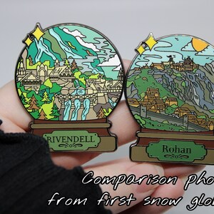 Peut inclure: Photo de comparaison de deux globes &agrave; neige en &eacute;mail. Le premier globe &agrave; neige pr&eacute;sente un paysage vert et brun avec une cascade et le texte "Rivendell". Le deuxi&egrave;me globe &agrave; neige pr&eacute;sente un paysage montagneux vert et brun avec le texte "Rohan".