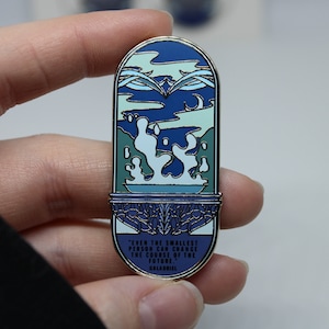 May include: A blue and green enamel pin with a quote from the book "The Lord of the Rings" by J.R.R. Tolkien. The quote reads: "Even the smallest person can change the course of the future." - Galadriel.