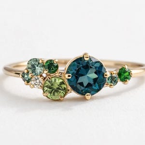 Può includere: Un set di tre ciotole impilabili in ceramica nei toni del blu, verde e bianco. Le ciotole presentano una smaltatura maculata e un design semplice e moderno. La ciotola più grande misura circa 15 cm di diametro.