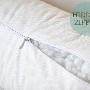 May include: A white pillow with a hidden zipper. The zipper is open, revealing the white filling inside.