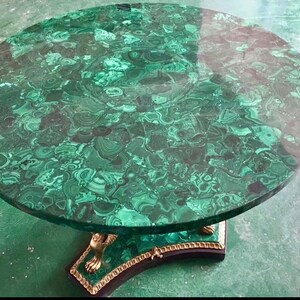 May include: A round table with a green malachite top and a gold-painted base with lion paw feet.