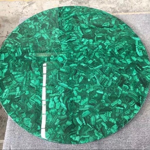 May include: A round green malachite table top with a swirling pattern.
