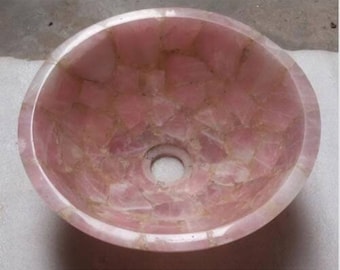 May include: A pink, round, mosaic-style bathroom sink made of rose quartz.