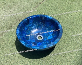 May include: A blue agate stone sink with a round shape and a drain hole in the center. The sink is made of natural stone and has a unique, organic pattern.