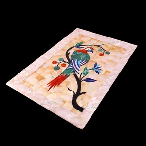 Könnte beinhalten: Ein rechteckiges Tablett aus eingelegtem Marmor mit einem farbenfrohen Papageien-Design. Der Papagei sitzt auf einem Ast mit roten Beeren. Das Tablett hat einen weißen Rand.