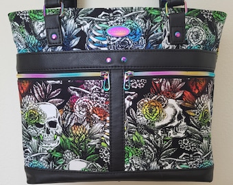 Tote with rainbow skulls and flowers. Pockets front, back and inside (good for cell phones), padded computer pocket, key fob. 13 x 12 x 4"