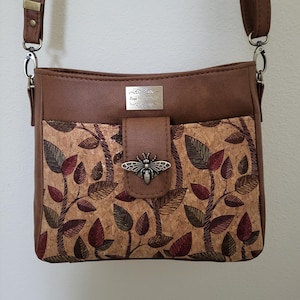 Leaves on cork combined w tan faux leather and lots of pockets on a classy mid-size purse/shoulder-bag/crossbody. 8 x 10 x 4.