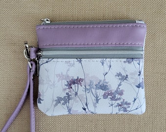 Delicate Lavender and gray flowers adorn this zippered wallet/wristlet, with 2 pockets, lavender accents and wristlet strap. 5.25" x 4.5"