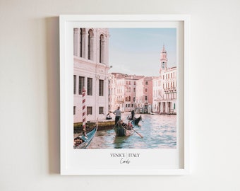 Puede incluir: Una fotografía enmarcada de un canal en Venecia, Italia. La foto muestra góndolas en el agua con edificios que bordean el canal. El texto "Venice | Italy" y "Cords" está impreso en la parte inferior de la foto.