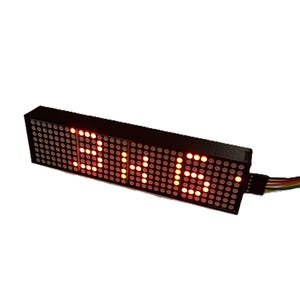 May include: A rectangular black LED display showing the time "3:15" in bright orange dots. The display has a grid of small lights and a multi-colored wire attached to the side.