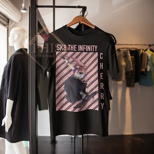 May include: Black t-shirt with a pink and white striped background featuring an anime character skateboarding. The text "SK8 THE INFINITY CHERRY" is printed on the shirt.