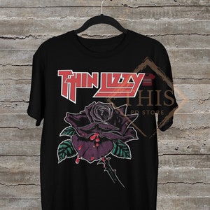 May include: Black t-shirt with a red and white "Thin Lizzy" logo and a black rose with red dripping blood.