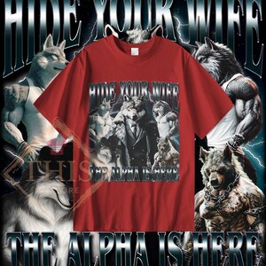May include: Red t-shirt with a graphic print of a wolf wearing a suit and the text "Hide Your Wife The Alpha Is Here".