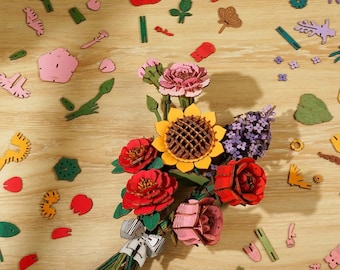 May include: A wooden DIY flower kit with a bouquet of assembled flowers, including a sunflower, roses, and lavender. The kit includes individual pieces in various colors, with the text "Everything You Need".