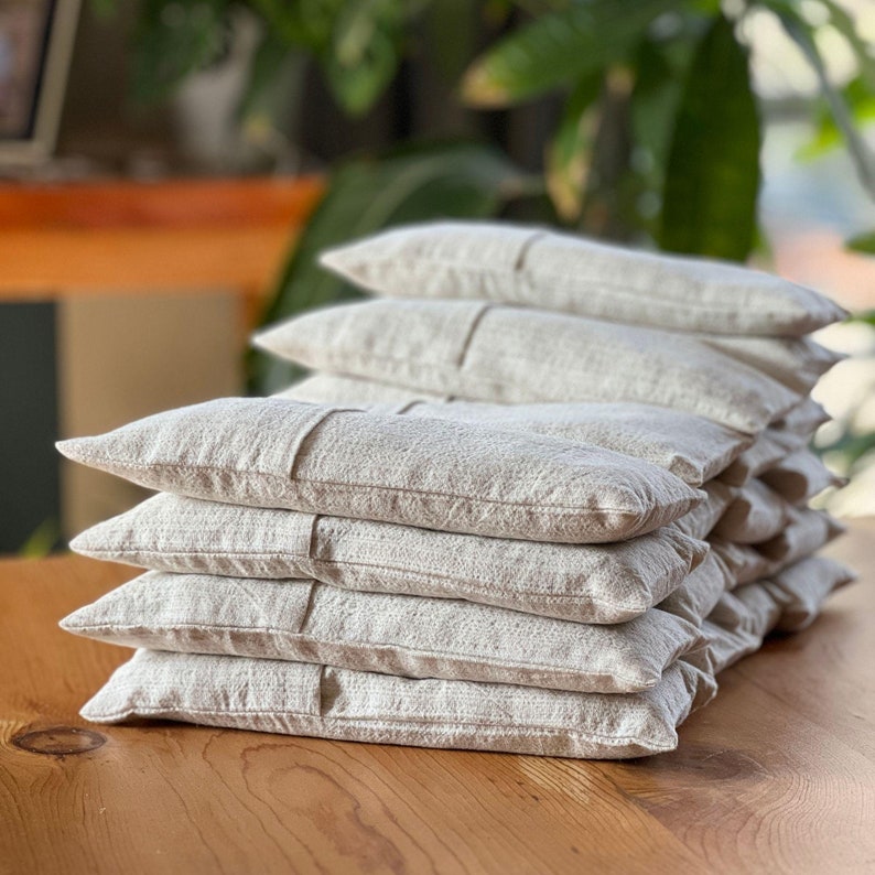 Organic linen lavender eye pillow placed on a wooden tray, showcasing its soft texture and natural tones.