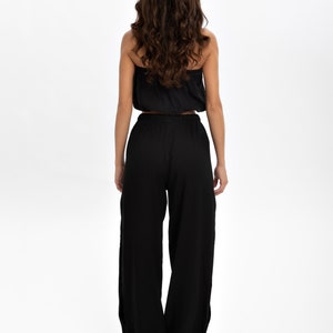 Indulge in the perfect fusion of natural comfort and bohemian elegance with these pants, meticulously crafted from 100% cotton. Their high-waist design, side slit, and tie belt seamlessly combine fashion with practicality.